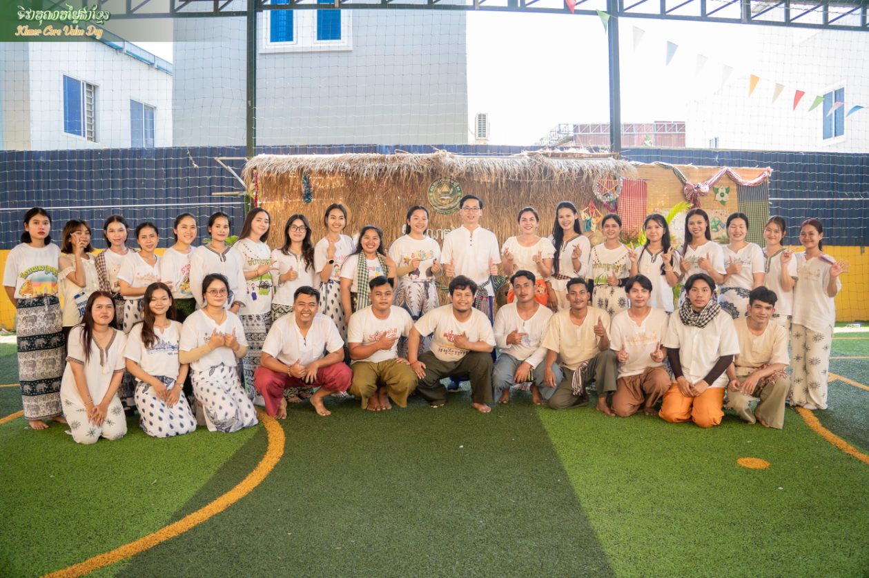 Staff in traditional Khmer dress gather on the sports field