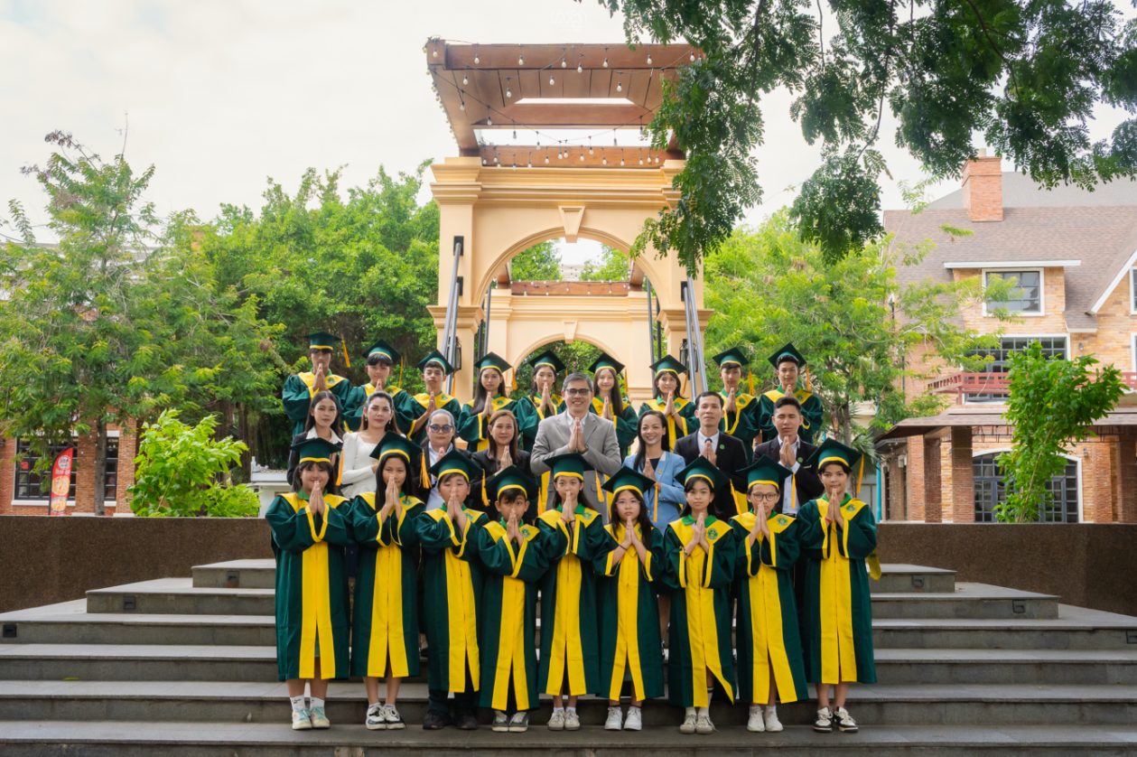 Graduating students and teachers pose on the steps of a campus
